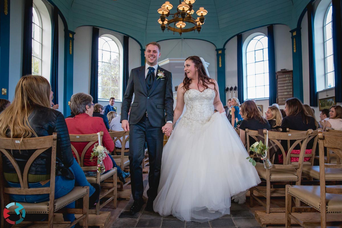 Bruidspaar loopt door het middenpad van het kerkje van Drimmelen uit