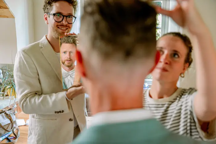 Twee bruidsfotografen fotograaf in de ochtend bij de bruidegom