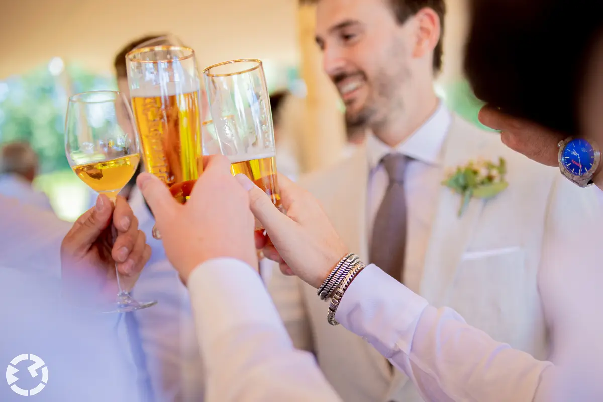 Mensen proosten samen met bierglazen en wijnglas.