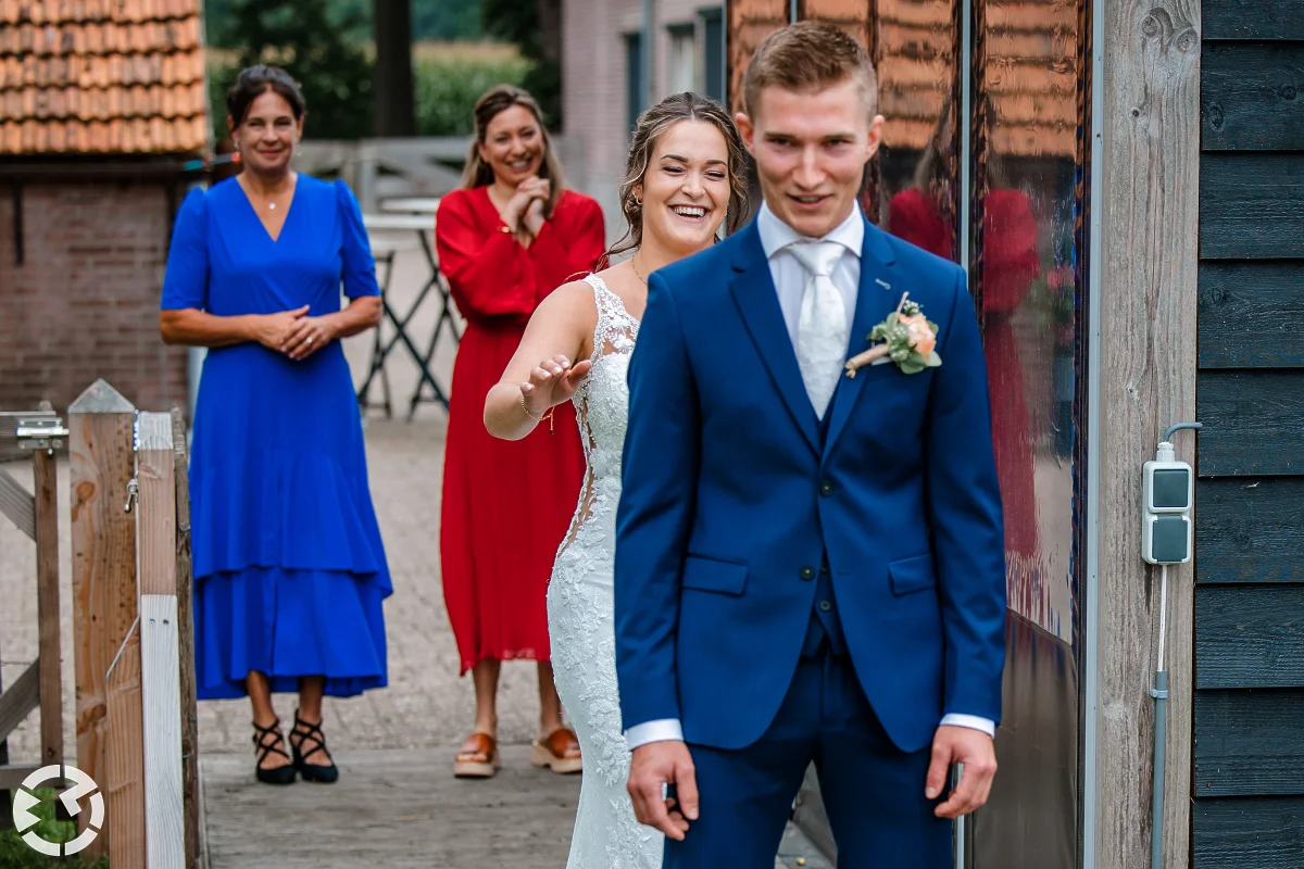 de eerste ontmoeting buiten met het bruidspaar waarbij de bruidegom met zijn rug naar de bruid toe wacht