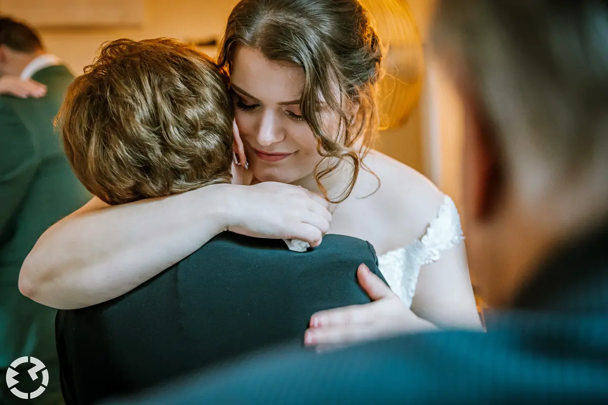 Close-up van bruid die een vrouw een emotionele knuffel heeft.