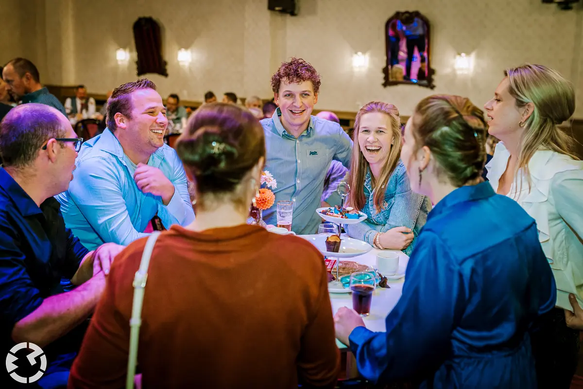 Gasten van de bruiloft om een staan tafel tijdens de trouwreceptie bij Het Chaamse Wapen.