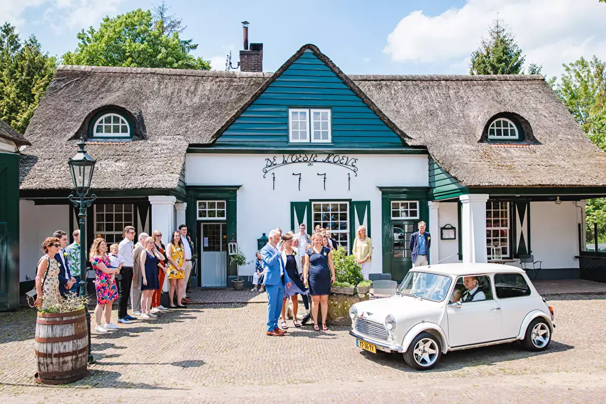 Bruidspaar komt aan in de kleine witte auto bij de Woese Hoeve in Beekbergen | Gelderland