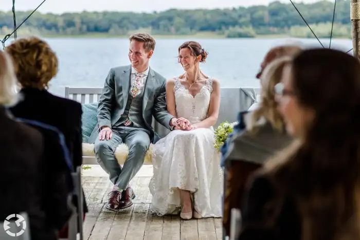 Bruidspaar tijdens hun trouwceremonie bij het Houtse Meer.