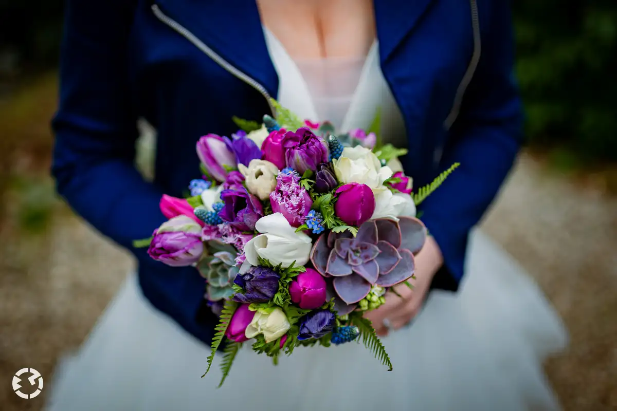 Bruidsboeket met kleurrijke combinatie van voorjaarsbloemen en moderne accenten.