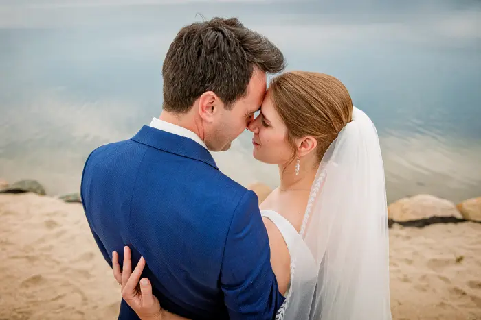Leuk bruidspaar aan het strand van Het Houtse Meer innige fotoshoot