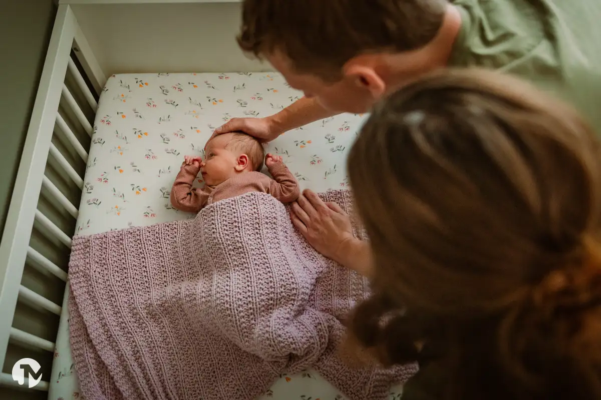 Baby wordt naar bed gebracht tijdens een life style baby fotoshoot