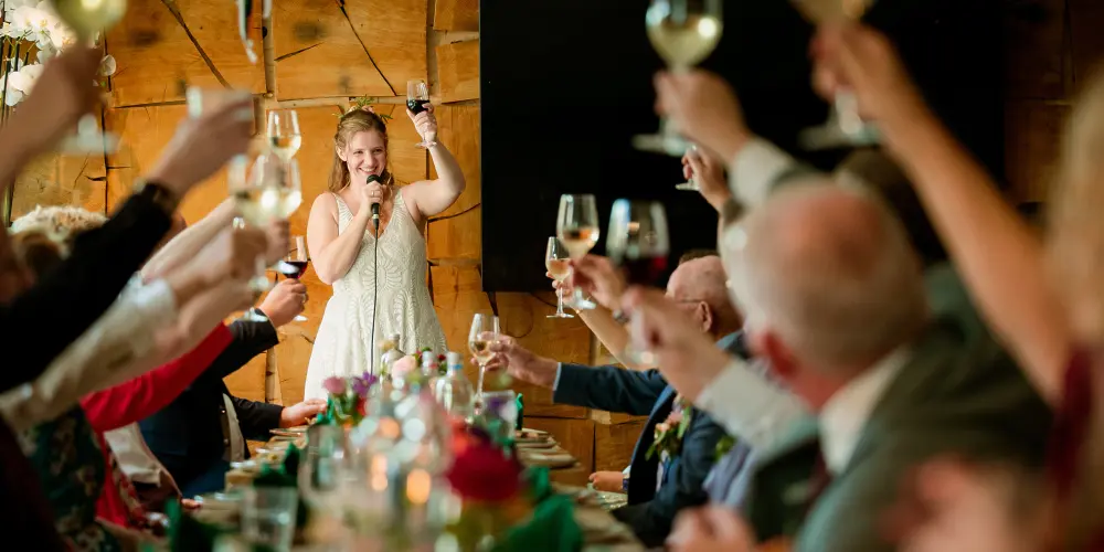 Bruid toast tijdens diner op trouwdag Otterlo op vakantiepark