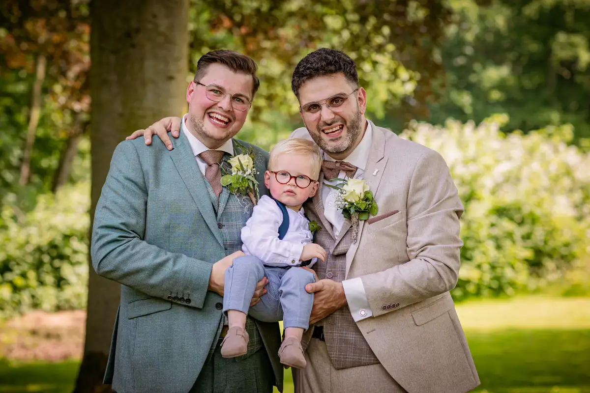 Bruidspaar poseert met een kindje dat aanwezig was op hun bruiloft.