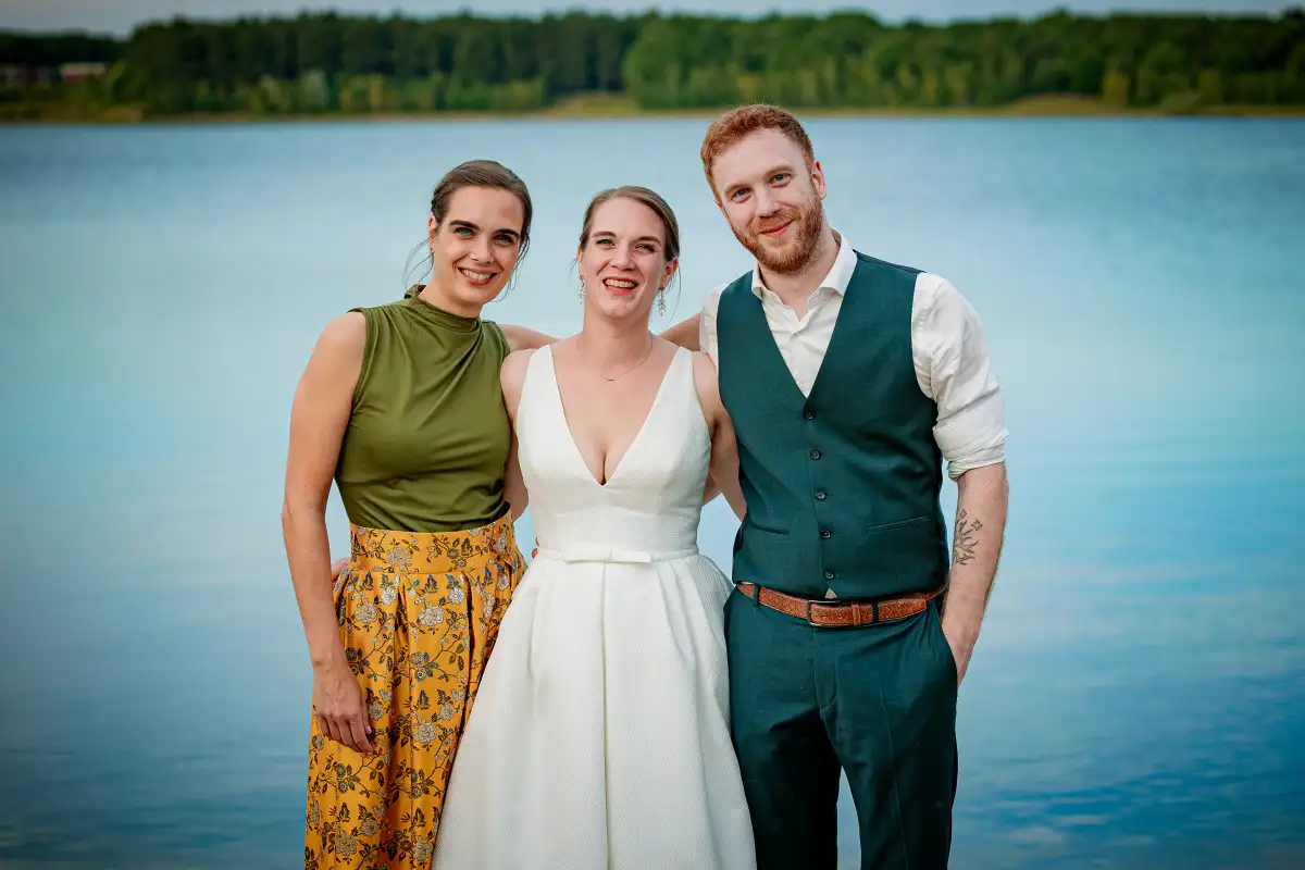 Bruid met haar zus en broer poseren tijdens groepsfoto's