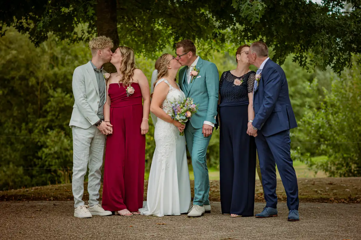 Gezinsfoto waarbij stelletjes elkaar een kus geven voor een spontanere foto.