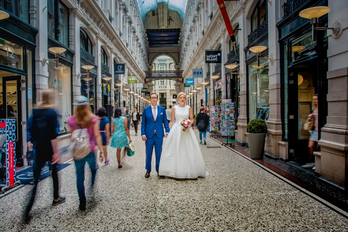 Creatief beeld van bruidspaar met beweging in een winkelstraat in Den Haag.