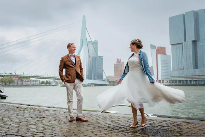 Bruid draait voor bruidegom met de Erasmusbrug op de achtergrond