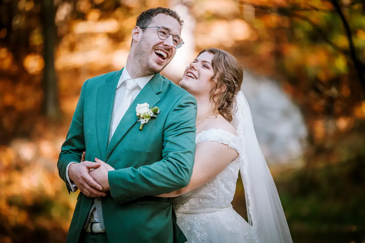 Fotoshoot van bruidspaar in de natuur met herfstkleuren.