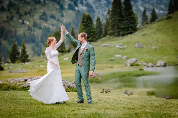 Bruidspaar danst tijdens hun fotoshoot in de Zwitserse bergen.