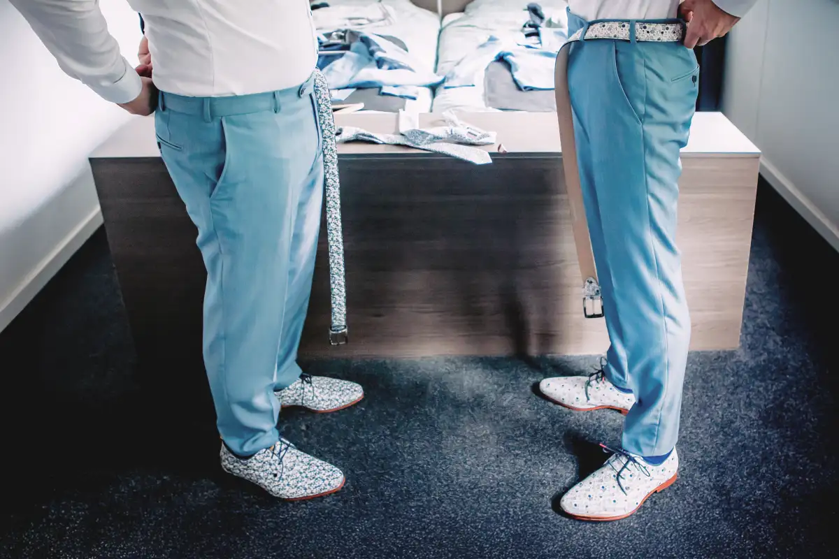 Twee bruidegoms halen hun riem op hun slaapkamer door hun broek. 