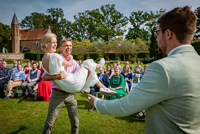 bruid wordt door vader op een unieke manier weggegeven trouwen warm gezellig trouwfotografie